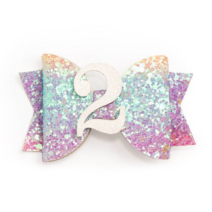 Every little girl needs the perfect hair clip to complete her look! The Pastel Rainbow #2 Clip is the perfect hair accessory for celebrating a 2nd birthday. Features: Pastel rainbow glitter bow with white glitter #2 Ribbon-covered alligator clip to grip the hair Glitter accents are “shed free” One size fits all Pair this hair clip with a matching Sweet Wink tutu and shirt for a complete head-to-toe outfit!