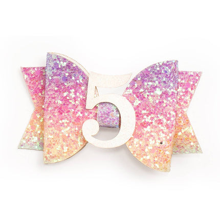 Every little girl needs the perfect hair clip to complete her look! The Pastel Rainbow #5 Clip is the perfect hair accessory for celebrating a 5th birthday. Features: Pastel rainbow glitter bow with white glitter #5 Ribbon-covered alligator clip to grip the hair Glitter accents are “shed free” One size fits all Pair this hair clip with a matching Sweet Wink tutu and shirt for a complete head-to-toe outfit!