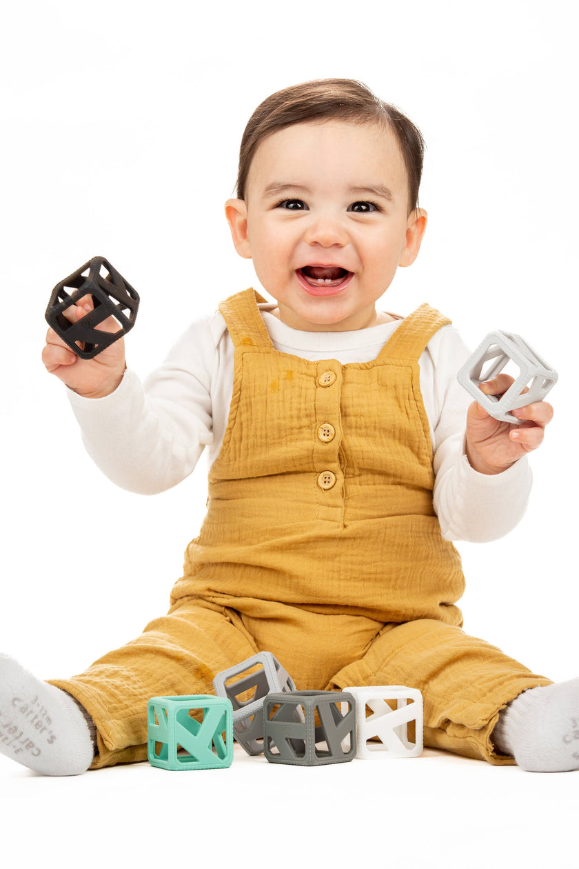 The Stack N Chew Mini Cube is a developmental teething toy. It's BPA-Free and made of food-grade silicone making it safe for baby's tender gums. The flexible holes help strengthen baby's gripping skills. The contrasting modern colors stimulate hand-eye coordination and promote motor skills such as stacking and carrying. Easy to travel with, it encourages imagination - even for water play! Package contains 6 mini cubes.